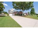 Inviting brick residence featuring a long driveway, large lawn, and mature trees, blending comfort with curb appeal at 3027 Biltmore Woods Dr, Buford, GA 30519