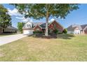 Beautiful brick home with a well-maintained lawn, mature tree, and ample driveway space offers suburban charm at 3027 Biltmore Woods Dr, Buford, GA 30519