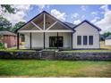 Charming backyard featuring a covered patio with stylish support beams and a stone retaining wall at 532 Rockbridge Rd, Lilburn, GA 30047