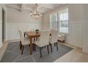 Bright dining room features modern chandelier, decorative rug and wainscoting at 297 Delta Dr, Mcdonough, GA 30252