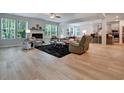 Open concept living room with fireplace, wood floors, and large windows at 297 Delta Dr, Mcdonough, GA 30252