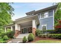 Charming blue two-story home featuring a welcoming front porch with brick accents and lush landscaping at 1020 Austin Ne Ave, Atlanta, GA 30307