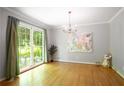 The dining room has hardwood floors, large windows looking out to the lush yard, and modern light fixtures at 2620 Clairmont Rd, Atlanta, GA 30329