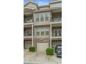 Townhome exterior with garages and private balconies, enhanced by manicured landscaping and parking at 3066 Quantum Ln # 24, Atlanta, GA 30341