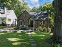 A brick home with a stone entryway and pergola accent, surrounded by lush green grass and mature trees at 978 Eden Se Ave, Atlanta, GA 30316