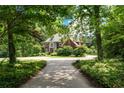 Beautiful brick home nestled among mature trees with a long, winding driveway at 11569 Finley St, Suwanee, GA 30024