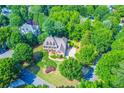 Aerial view of a brick home with lush green landscaping and mature trees in a beautiful neighborhood at 2111 Broadfield Run, Duluth, GA 30097