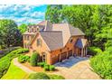Stately two-story brick home with an attached three-car garage and lush landscaping at 2111 Broadfield Run, Duluth, GA 30097