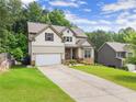 Beautiful two-story home with an attached two car garage, green lawn, and additional house next door at 275 Creek View Place, Canton, GA 30114