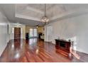 Spacious living room with hardwood flooring, tray ceiling and a chandelier fixture at 3075 Superior Dr, Dacula, GA 30019