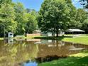 Scenic pond view with a charming shed and bridge adds tranquility to the backyard at 485 Angham Rd, Hiram, GA 30141
