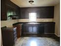 Functional kitchen with dark cabinetry, black appliances, and a window over the sink at 1094 Reynolds Ct, Morrow, GA 30260
