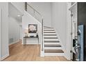 Bright foyer boasts hardwood floors, modern staircase with metal railing, and neutral decor at 1820 Hunters Moon Dr, Alpharetta, GA 30005