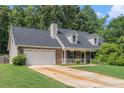 Traditional brick home with a two-car garage and a neatly maintained lawn at 220 Windpher Rdg, Hampton, GA 30228
