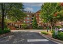 Exterior view of a traditional brick condo building featuring manicured lawns at 2300 Peachford Rd # 3411, Dunwoody, GA 30338