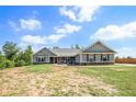 Inviting single-story home with a well-maintained front yard, showcasing its curb appeal on a sunny day at 569 Lovell Rd, Temple, GA 30179