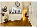 Bright hallway with hardwood floors, leading to a kitchen with white cabinets and stainless steel appliances at 7113 Silver Mine Xing, Austell, GA 30168