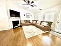 Cozy living room featuring hardwood floors, a fireplace, and a comfortable brown sectional sofa at 7113 Silver Mine Xing, Austell, GA 30168