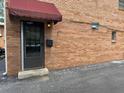 Apartment entry featuring a dark door with a maroon awning and brick facade at 1233 Woodland Ne Ave # 5, Atlanta, GA 30324