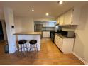An open kitchen with an eat-in bar, wooden floors, and white cabinets at 1233 Woodland Ne Ave # 5, Atlanta, GA 30324