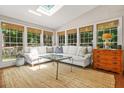 Bright sunroom with large windows, skylight, and comfortable white sofa at 3870 Windhurst Dr, Lilburn, GA 30047