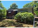 View of house with brick and siding, overgrown bushes, with a partly cloudy sky at 25 Candler Se Rd, Atlanta, GA 30317