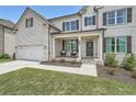 A two-story home with white brick, black shutters, and a covered front porch, perfect for relaxing outdoors at 7820 Bristol Valley Dr, Cumming, GA 30028