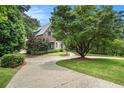 Exterior view showing a large circular driveway and lush landscaping around this beautiful brick Tudor home at 927 Berkshire Ne Rd, Atlanta, GA 30324