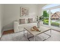 Cozy living room featuring a modern sofa, patterned rug, and large picture window at 1010 Graystone Xing, Alpharetta, GA 30005