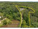 Aerial shot of home within lot and trees, with a pond nearby and private drive at 212 Postell Rd, Dallas, GA 30157