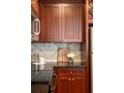 Close-up of kitchen featuring granite countertops, a tile backsplash, and wood cabinetry at 2277 Peachtree Ne Rd # 611, Atlanta, GA 30309