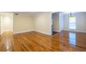 Spacious living room with hardwood floors, crown molding, and an open doorway to the kitchen area at 3091 Colonial Way # I2, Atlanta, GA 30341