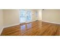 Open floor plan with hardwood floors, natural light streaming through windows, and a door leading outside at 3091 Colonial Way # I2, Atlanta, GA 30341