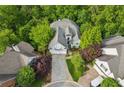 Aerial view of a two-story home with balcony, two-car garage, nestled amongst trees at 4217 Wieuca Overlook Ne, Atlanta, GA 30342