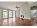Bright living room with a fireplace, vaulted ceilings, and large windows offering natural light and scenic views at 616 Lone Oak Ct, Lithonia, GA 30058