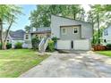 Charming gray home featuring a two-car garage, beautiful landscaping, and a welcoming front entrance at 1358 Millstream Trl, Lawrenceville, GA 30044