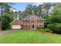 Charming brick home with a lush green lawn and mature trees at 739 Dushea Nw Ct, Kennesaw, GA 30144