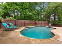 Backyard pool with lounge chairs and a wooden fence, perfect for relaxation and privacy at 739 Dushea Nw Ct, Kennesaw, GA 30144