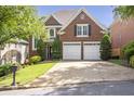 Charming brick home with a well-manicured lawn, a two-car garage, and lush landscaping at 1064 Saint James Xing, Brookhaven, GA 30319