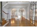 Grand foyer with hardwood floors, arched doorways, a staircase, and a statement mirror at 1064 Saint James Xing, Brookhaven, GA 30319