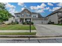 Charming two-story home featuring stone accents, a three-car garage, and beautifully landscaped front yard at 1200 Bar Harbor Pl, Lawrenceville, GA 30044