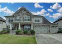 Charming two-story home featuring stone accents, a three-car garage, and beautifully landscaped front yard at 1200 Bar Harbor Pl, Lawrenceville, GA 30044