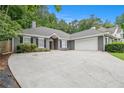 Well-maintained single-story home with a two-car garage and long driveway, situated on a lush lot at 703 Kirkwood Cir, Woodstock, GA 30189