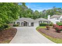 Landscaped front yard view of the single-story home with long driveway and inviting facade at 703 Kirkwood Cir, Woodstock, GA 30189