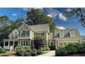 Beautifully landscaped home with green siding, brick accents, and a well-maintained lawn under a partly cloudy sky at 192 Chicopee Dr, Marietta, GA 30060