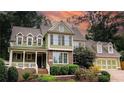 Inviting two-story home with a welcoming front porch, brick accents, and manicured landscaping, garage on right at 192 Chicopee Dr, Marietta, GA 30060