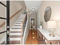 Welcoming entryway with hardwood floors, staircase, and decorative table at 2303 Waters Edge Trl, Roswell, GA 30075