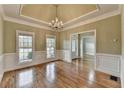 Dining room with hardwood floors, a tray ceiling, decorative trim, and a chandelier at 3426 Olivia Grace Way, Dacula, GA 30019