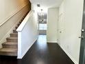 Inviting foyer with dark hardwood floors and staircase leading to the upper level of the home at 1606 Larkspur Trl, Conyers, GA 30012