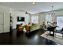 Bright living room with dark hardwood floors, modern decor, and a dining area with stylish furniture at 1606 Larkspur Trl, Conyers, GA 30012